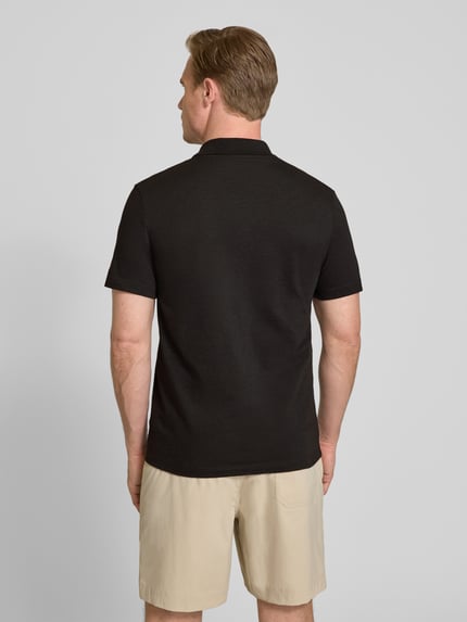 Männermodel trägt Regular Fit Poloshirt aus Baumwoll-Mix von Lacoste, Optik: Unifarben, Logo-Patch, Polokragen, Kurzarm, Ganzkörperansicht Rückansicht.
