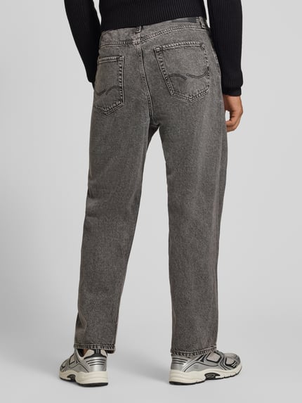 Męski model nosi szare jeansy Baggy Jeans im 5-Pocket-Design Model 'ALEX' od JACK & JONES z bawełny, 5 kieszeni, zapięcie na guzik i zamek błyskawiczny, Szerokość w rozmiarze 32/32: 42 cm, Długość wewnętrzna nogawki w rozmiarze 32/32: 74 cm, widok całej sylwetki od tyłu.