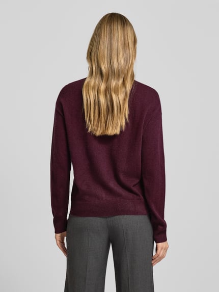 Frauenmodel trägt Relaxed Fit Strickpullover aus reinem Kaschmir Modell 'FASCONA' von BOSS in Melange-Bordeaux, gerippte Abschlüsse, Ganzkörperansicht Rückansicht.