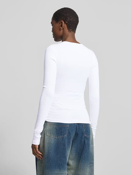 Frauenmodel trägt Longsleeve mit durchgehender Knopfleiste von black palms, weiß, unifarben, Rippstruktur, geschlitzter Saum, Ganzkörperansicht Rückansicht.