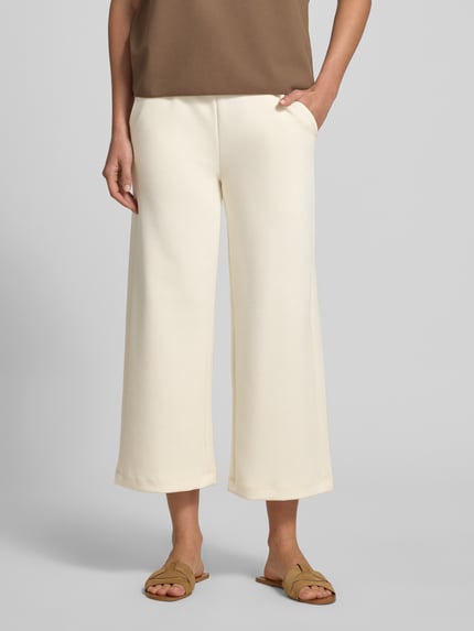 Vrouwenmodel draagt Wide Fit Sweatpants in verkorte pasvorm model 'Banu' van Soyaconcept in crème, elastische materiaalmix met modal, wide fit, elastische band met tunnelkoord, dames sweatpants, geheel vooraanzicht, detailopname onderlichaam.