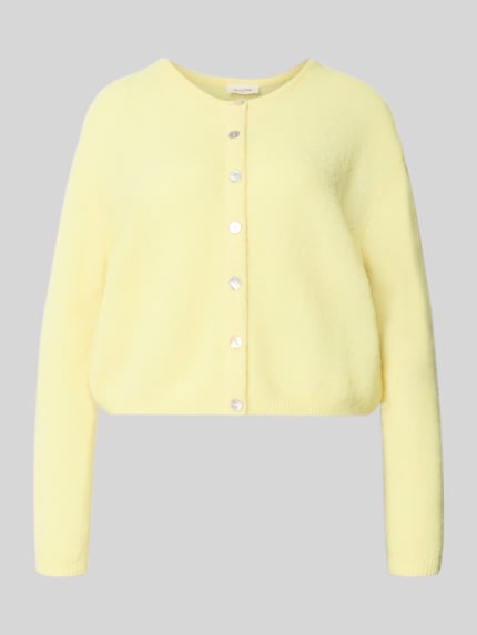 Produktfoto, Relaxed Fit Strickjacke aus Woll-Mix mit Leinen-Anteil von American Vintage, żółty kolor, przezroczyste guziki, krój relaxed fit, mieszanka wełny i lnu, długi rękaw, prążkowane ściągacze, długość tyłu w rozmiarze S 52 cm, długość rękawów w rozmiarze S 56 cm.