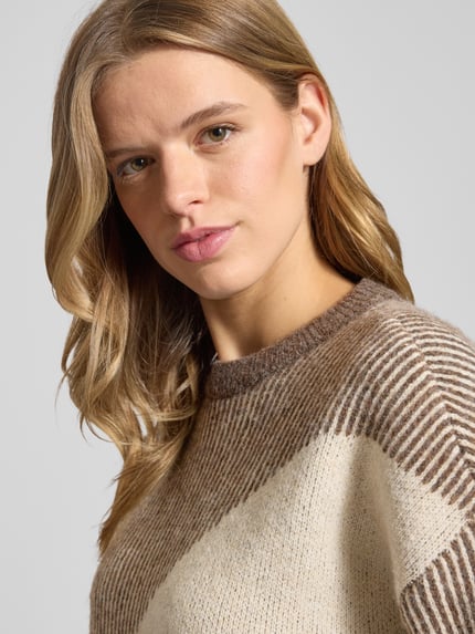 Frauenmodel trägt Loose Fit Strickpullover mit Allover-Muster Modell 'LINNA' von Pieces, gestreift, Crew Neck, Strick-Textur, Nahaufnahme Oberkörper.