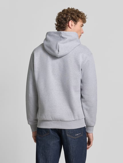 Männermodel trägt Relaxed Fit Hoodie aus Baumwoll-Mix von Lacoste in Hellgrau mit glatter Textur, Ganzkörperansicht Rückansicht. Herren Sweatshirt von Lacoste