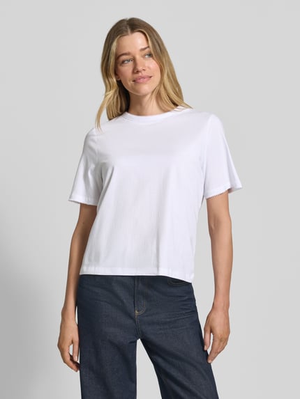 Frauenmodel trägt Regular Fit T-Shirt aus reiner Baumwolle Modell 'ASSIA' von Selected Femme, unifarben, Rundhals, Kurzarm, Ganzkörperansicht von vorne.
