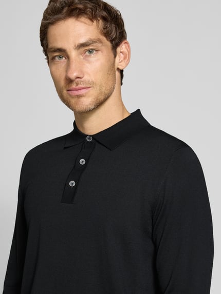 Männermodel trägt Regular Fit Strickpullover aus reiner Schurwolle mit Polokragen von MAERZ Muenchen, schwarzer Stoff, Nahaufnahme Oberkörper.