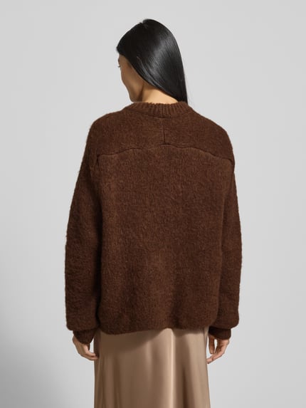 Frauenmodel trägt Strickpullover mit gerippten Abschlüssen von Smith and Soul in Braun, lockerer Schnitt, Material-Mix, Ganzkörperansicht Rückansicht.