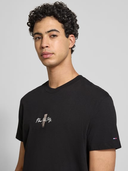 Männermodel trägt Regular Fit T-Shirt aus reiner Baumwolle Modell 'SIGN BLOCK' von Tommy Jeans, Optik: Unifarben, Nahaufnahme Oberkörper.