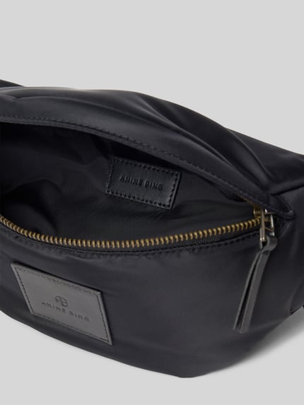 Produktfoto, schwarze Bauchtasche mit Klickverschluss von Anine Bing aus Satin, Label-Patch, Haupt- und Rückseitenfach mit Reißverschluss, 37x15x11 cm