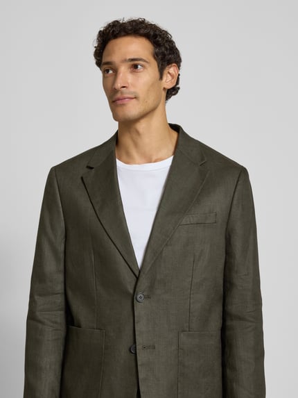 Männermodel trägt Regular Fit Sakko aus reinem Leinen Modell 'BAILEY' von Selected in olivgrün, Herren Sakko, Nahaufnahme Oberkörper.
