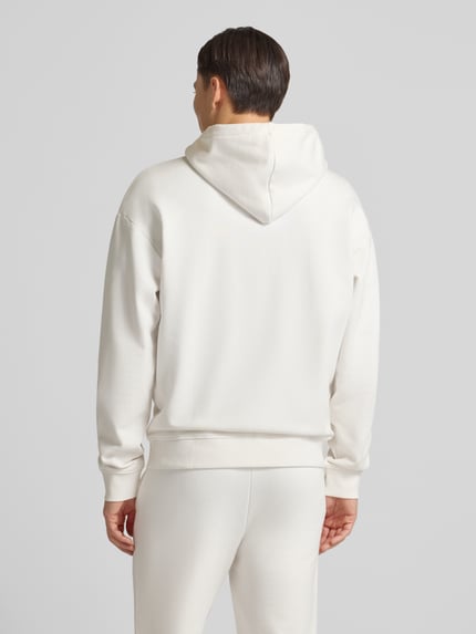 Männermodel trägt Relaxed Fit Sweatjacke aus reiner Baumwolle Modell 'DAPOZIP' von HUGO in Unifarben, Ganzkörperansicht Rückansicht.