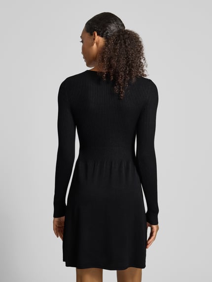 Frauenmodel trägt Regular Fit Strickkleid aus Viskose-Mix Modell 'ALMA' von ONLY in Schwarz, feine Rippenstruktur, Damen Strickkleid, Ganzkörperansicht Rückansicht.