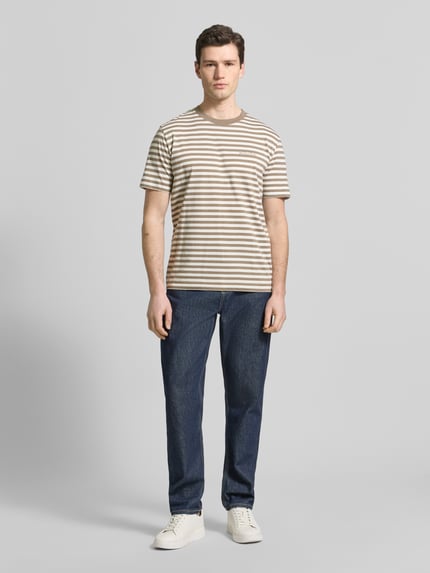 Männermodel trägt Regular Fit T-Shirt aus reiner Baumwolle von Marc O'Polo, gestreiftes Allover-Muster, kurzarm, Jersey, Ganzkörperansicht von vorne.