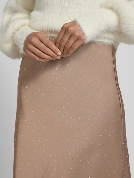Vrouwenmodel draagt Maxirock met elastischem Bund van Neo Noir, beige met fijne stippen, materiaal-mix met stretch, detailopname taille.