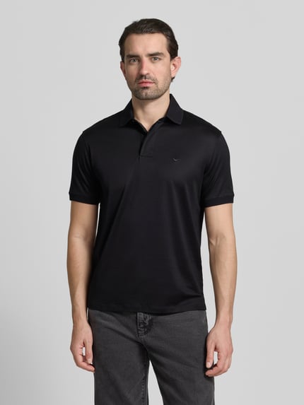 Männermodel trägt Poloshirt mit kurzer Knopfleiste von Emporio Armani in Schwarz, Lyocell-Baumwoll-Mix, Regular Fit, Ganzkörperansicht von vorne.