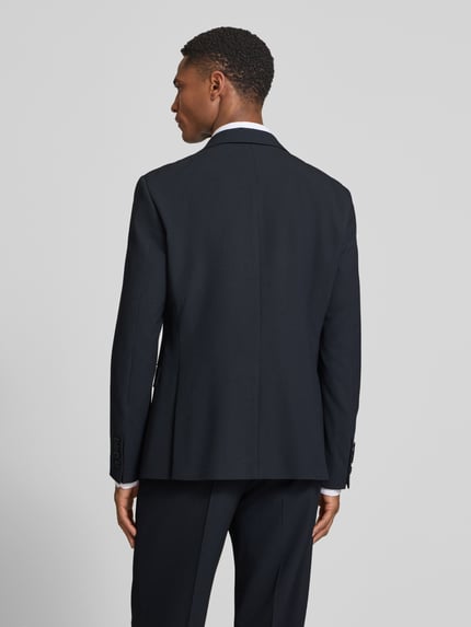 Männermodel trägt Anzug mit Reverskragen und Hose mit elastischem Bund von JOOP! Collection in dunklem Blau, Regular Fit, Rückenansicht Ganzkörperansicht.