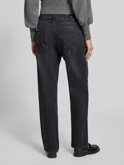 Frauenmodel trägt Regular Fit Straight Fit Jeans mit Bundfalte Modell 'Gina Straight' von MAC in dunklem Denim, 5-Pocket-Design, Ganzkörperansicht Rückansicht.