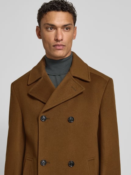 Männermodel draagt Regular Fit lange jas met reverskraag Model 'BEALE' van JOOP! Collectie in wolmix, knoopsluiting, steekzakken, nahaufnahme oberkörper.