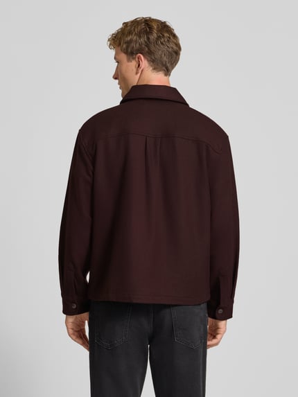 Männermodel trägt Jacke mit Brusttaschen Modell 'Atoka' von Carhartt Work In Progress, dunkles Braun, Baumwoll-Mix, Ganzkörperansicht Rückansicht.