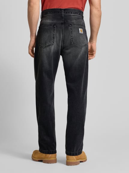 Männermodel trägt Jeans im 5-Pocket-Design Modell 'Landon' von Carhartt Work In Progress in Schwarz, gerade geschnitten, Rückansicht Ganzkörperansicht.