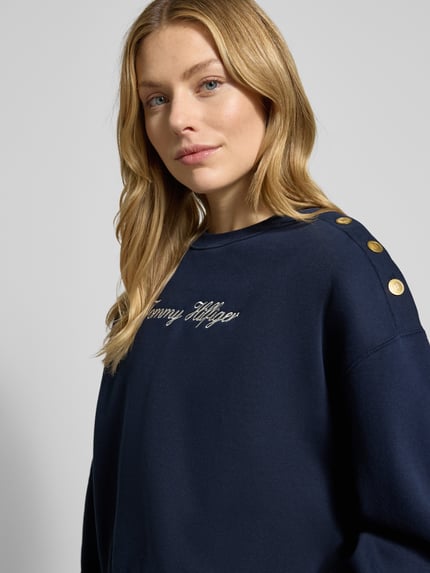 Vrouwenmodel draagt Relaxed Fit Sweatshirt uit katoenmix van Tommy Hilfiger, effen kleur, labelstiksel, ronde hals, lange mouwen, close-up bovenlichaam.