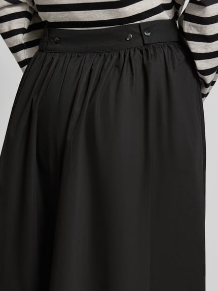Frauenmodel trägt Midirock mit seitlichem Reißverschluss Modell 'SALLY' von Topshop aus reiner Baumwolle in Schwarz, Nahaufnahme Oberkörper.