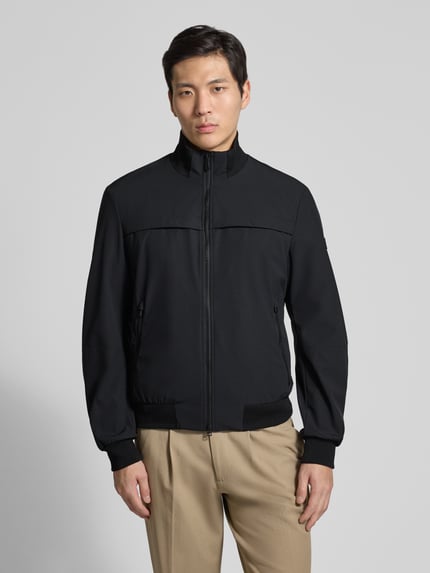 Männermodel trägt Jacke mit Stehkragen Modell 'POTOSI' von Peuterey in Schwarz, Material-Mix mit Stretch, Ganzkörperansicht von vorne.
