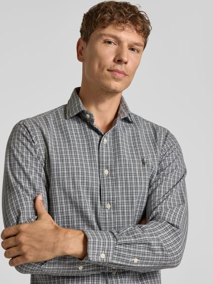 Männermodel trägt Regular Fit Freizeithemd aus reiner Baumwolle von Polo Ralph Lauren in Grau mit feinem Karomuster, Nahaufnahme Oberkörper.