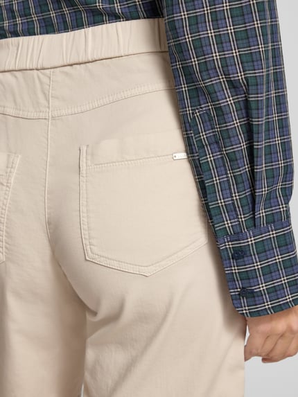 Kobiece model nosi Straight Fit Shorts mit Gesäßtaschen Modell 'Sue' von TONI, mieszanka bawełny, elastyczny pas, detal tylnej kieszeni, zbliżenie pleców.