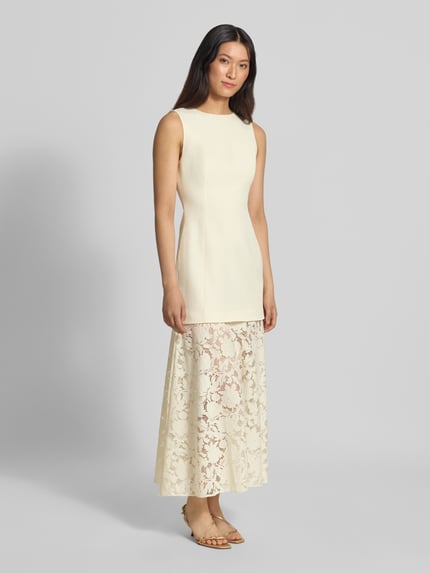 Vrouwenmodel draagt avondjurk uit mix van linnen en viscose, model 'Joan' van Forever New, 2-in-1-look met kanten rok, maxilengte, effen lichte kleuren, vrouwelijke texturen. Volledig frontaal beeld van het hele lichaam. Context: Dames avondjurk van Forever New, mix van linnen en viscose, nauwsluitende pasvorm, model 'Joan', a-lijn, mouwloos design, 2-in-1-look, rokdeel van bloemenkant, maxilengte, ruglengte bij maat 36: 133 cm, borstwijdte bij maat 36: 38 cm.