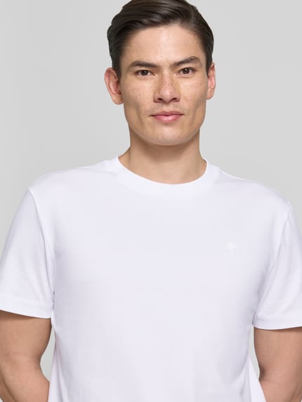 Männermodel trägt T-Shirt mit Rundhalsausschnitt Modell 'Carlonito' von JOOP! Collection in Weiß, Baumwoll-Mix, Nahaufnahme Oberkörper.