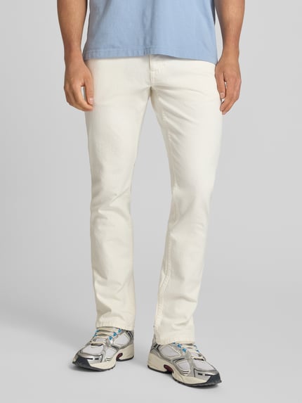 Männermodel trägt Slim Fit Jeans aus Baumwoll-Mix Modell 'SCANTON SLIM' von Tommy Jeans, Optik: Unifarben, 5-Pocket-Design, Ganzkörperansicht von vorne.