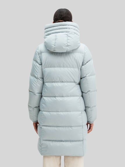 Frauenmodel trägt Regular Fit Daunenmantel mit Label-Print von Marc O'Polo in hellem Blau, gestepptes Design, Damen Daunenmantel, Ganzkörperansicht Rückansicht.