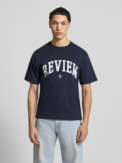 Mannenmodel draagt T-Shirt met Label-Print en Rundhalsausschnitt van REVIEW, katoen, regular fit, donkerblauw, witte print, frontale totaalopname.