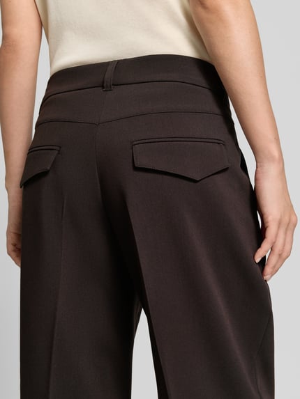 Frauenmodel trägt Cropped Barrel Leg Hose mit Bundfalten Modell 'Ortensia' von CAMBIO in Dunkelbraun mit Webstruktur, Nahaufnahme Rückansicht.