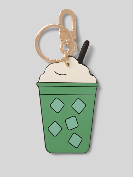Produktfoto, zielony i kremowy breloczek do kluczy z karabińczykiem Modell 'MY MATCHA LATTE' od Seidenfelt, motyw napoju, tekstura gładka