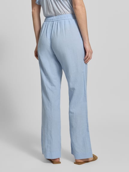 Vrouwenmodel draagt stoffen broek met mix van katoen en linnen, elastische band, steekzakken, Sonar model van Neo Noir, geheel achteraanzicht.