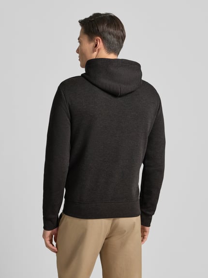 Męski model nosi Hoodie mit Kapuze od Polo Ralph Lauren, czarny, bawełniany miks, luźny krój, widok całej sylwetki od tyłu.