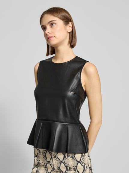 Frauenmodel trägt Top in Leder-Optik mit rückseitigem Knopfverschluss von Gina Tricot, A-Linie, Rundhalsausschnitt, Ganzkörperansicht von vorne.