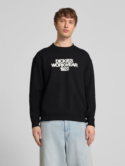 Männermodel trägt Sweatshirt mit Label-Print Modell 'TORREY' von DICKIES in Schwarz, Baumwoll-Mix, Lockerer-Schnitt, Rundhalsausschnitt, Gerippte-Abschlüsse, Ganzkörperansicht von vorne.