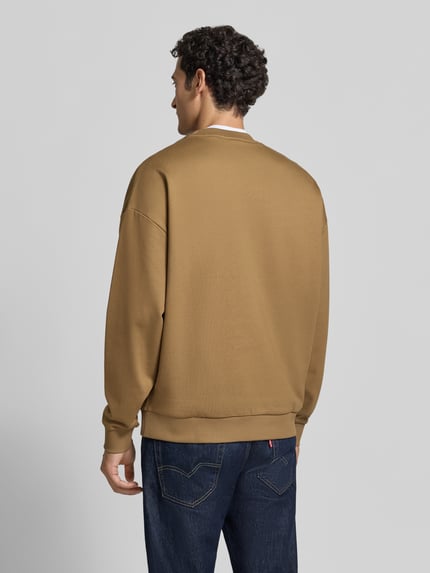 Männermodel trägt Regular Fit Sweatshirt aus reiner Baumwolle Modell 'Dinex' von HUGO in Braunton, lockere Passform, Herren Sweatshirt, Ganzkörperansicht Rückansicht.