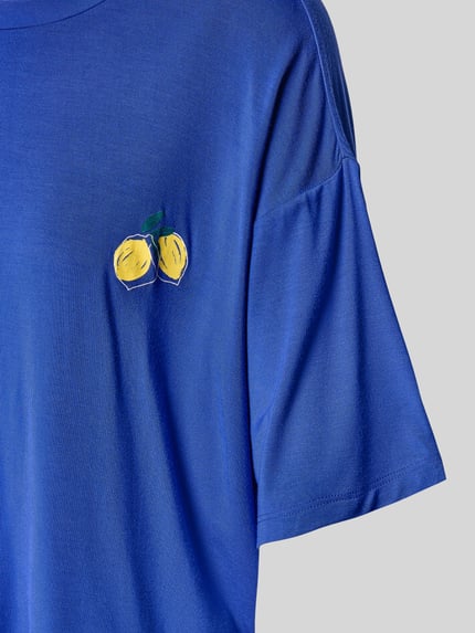 Vrouwenmodel draagt Pyjama aus Modal-Mix mit 3/4-Arm van Schiesser in helderblauw met citroenprint, los vallende fit, 3/4-mouwen, detailopname bovenlichaam.