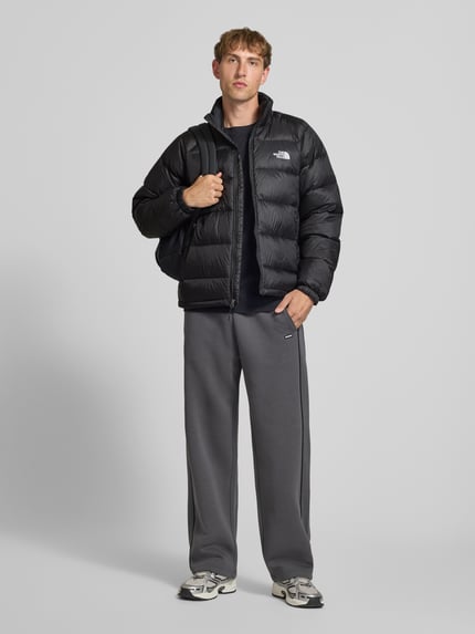 Männermodel trägt schwarze Steppjacke mit Label-Stitching Modell 'HYDRENALITE DOWN JACKET' von The North Face, Regular Fit, Reißverschluss, seitliche Eingrifftaschen, Stehkragen, glatte Oberfläche, Ganzkörperansicht von vorne.