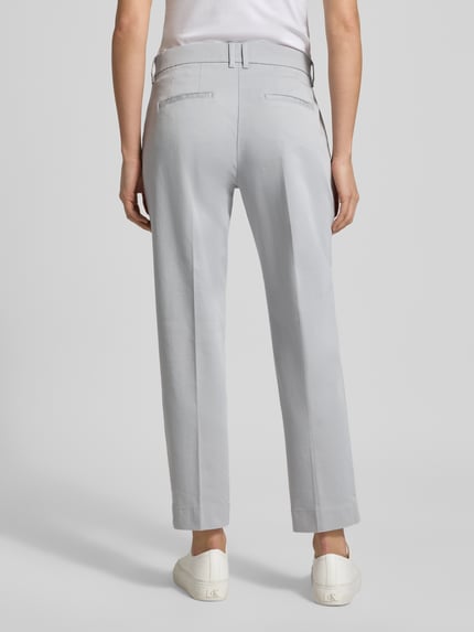 Modelka kobieca nosi Straight Fit Stoffhose mit Lyocell-Anteil Modell 'Mara' od Brax, jasnoszary kolor, kanty, krótszy krój, kieszenie, elastyczna mieszanka bawełny z lyocellem, szerokość w rozmiarze 36: 39 cm, długość nogawki: 68 cm, widok całej sylwetki z tyłu.