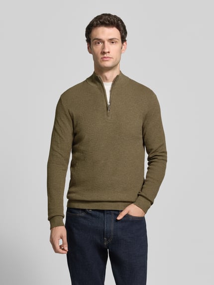 Männermodel trägt Slim Fit Strickpullover aus Baumwoll-Mix mit Troyer-Kragen von Profuomo in Oliv, elastische Abschlüsse, Ganzkörperansicht von vorne.