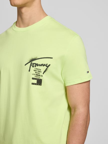 Männermodel trägt Regular Fit T-Shirt aus reiner Baumwolle von Tommy Jeans, Optik: Unifarben, Label-Schriftzug, Nahaufnahme Oberkörper.