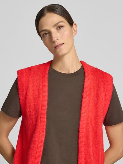 Kobiece model prezentuje Strickweste in offener Passform Modell 'BLUSH' od ICHI w kolorze intensywnej czerwieni, materiał z domieszką wełny, krój regular fit, długość tyłu w rozmiarze S: 48 cm, zbliżenie na górną część ciała.