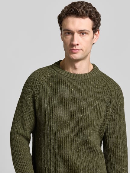 Männermodel trägt Pullover mit Raglanärmeln Modell 'KIAANO' von ARMEDANGELS, melierter Strick, Rundhals, olivgrün, Nahaufnahme Oberkörper.