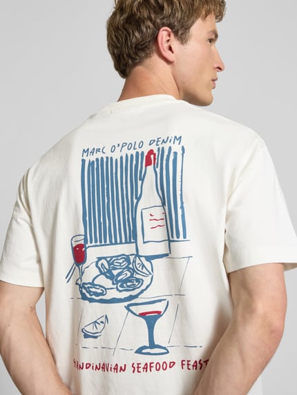 Männermodel trägt Relaxed Fit T-shirt uit puur katoen van Marc O'Polo Denim, look: effen kleuren met motiefprint, korte mouw, ronde hals, Ganzkörperansicht Rückansicht.
