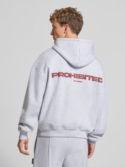 Männermodel trägt Relaxed Fit Hoodie aus Baumwoll-Mix mit Label-Detail von PROHIBITED, Hellgrau, Känguru-Tasche, Rückenansicht, KI-modifiziertes Bild